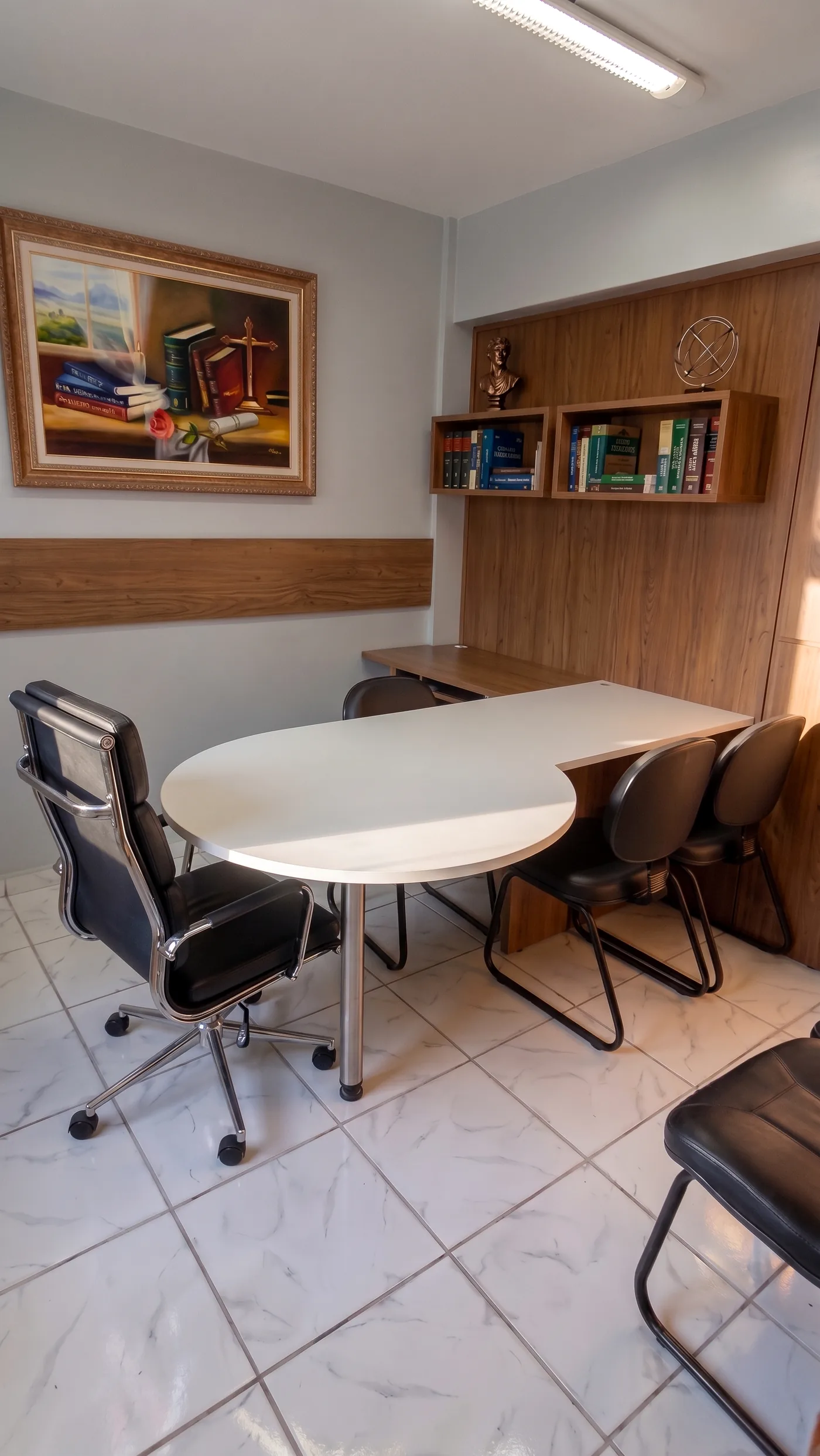 Sala de reuniões do escritório, com mesa oval, cadeiras e estantes de livros jurídicos